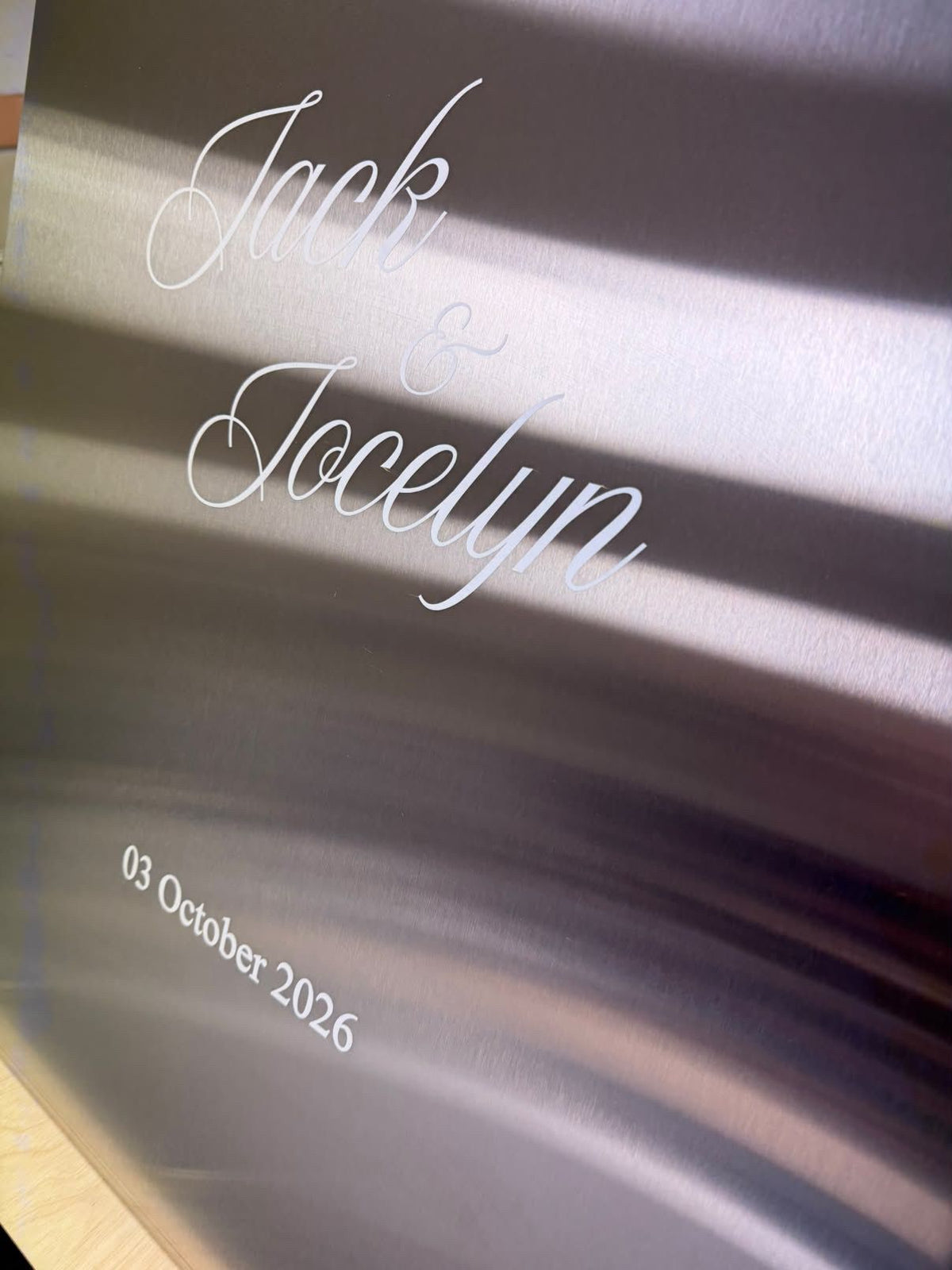 Brushed stainless steel A-frame: Jack & Jocelyn 03 October 2026 lettering close-up