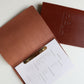 Tan leather menu open with a brass clip
