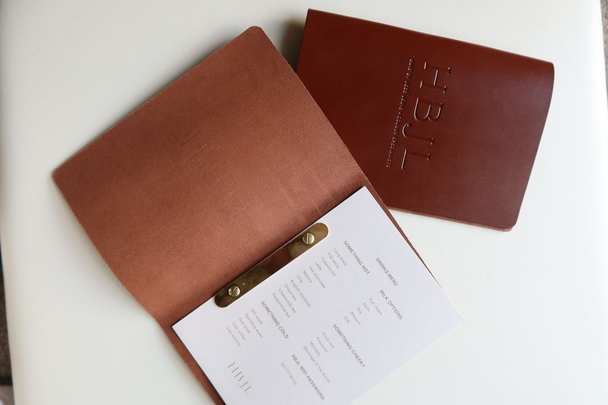 Tan leather menu open with a brass clip