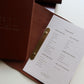 Tan leather menu open with a printed insert