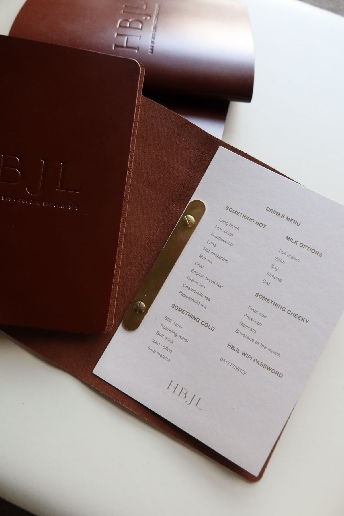 Tan leather menu open with a printed insert