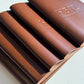 Diagonal stack of tan leather menus