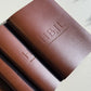 Close-up of debossed tan leather menus stacked