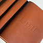 Stack of debossed tan leather menus