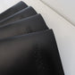 Stack of black debossed leather menus