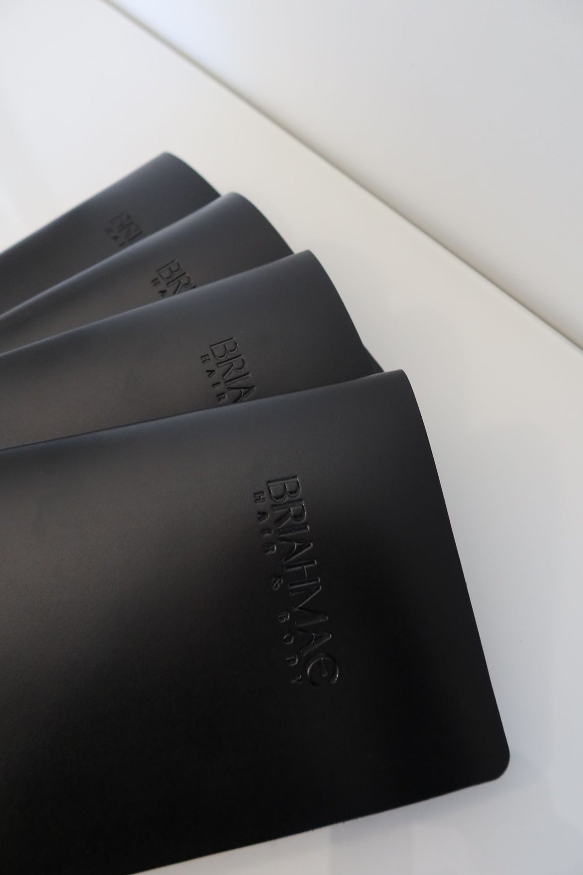 Stack of black debossed leather menus