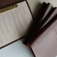 Brown leather menus with one open to a printed insert