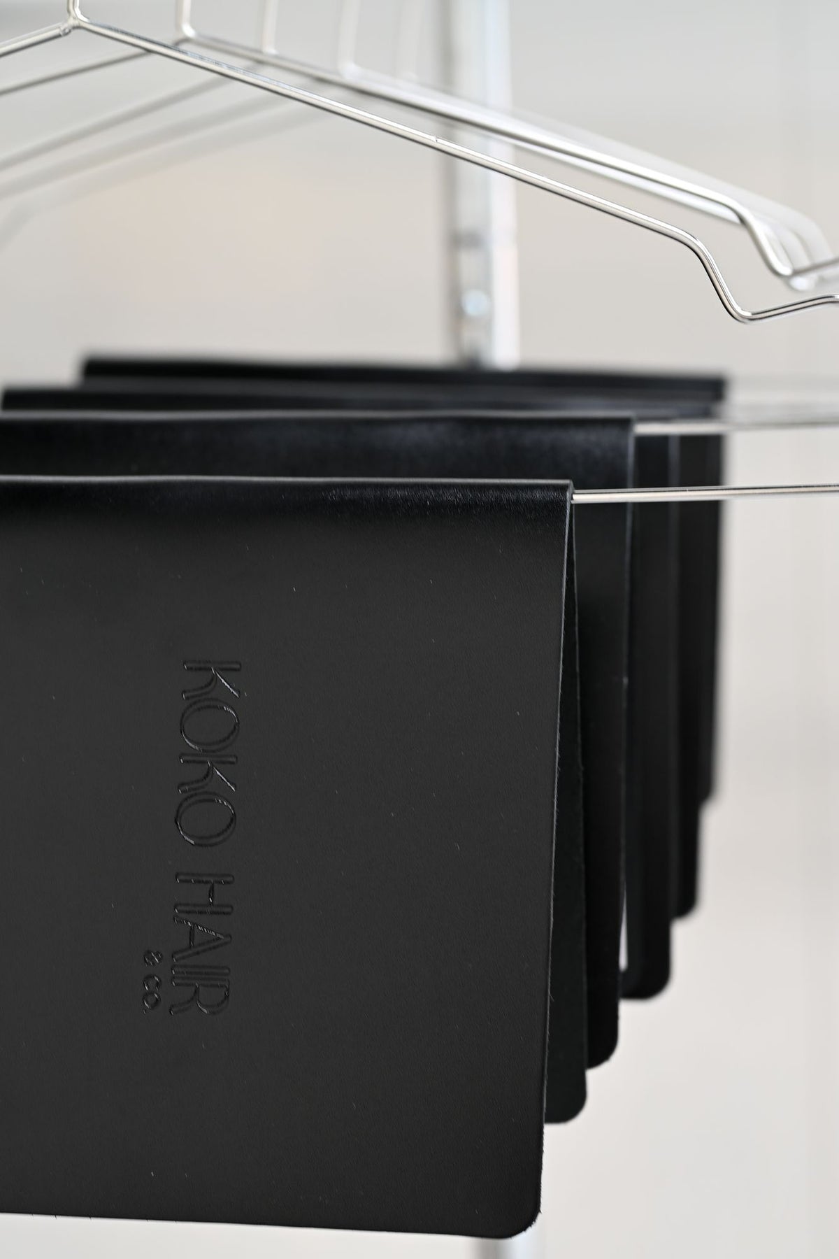 Black leather menus hanging on a chrome rack