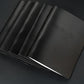 Black leather menus fanned, from above